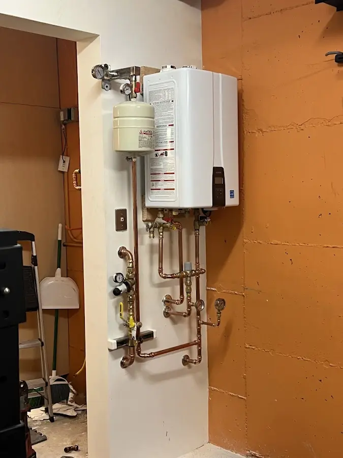 Plumbing technician inspecting water heater connections in Fairwood